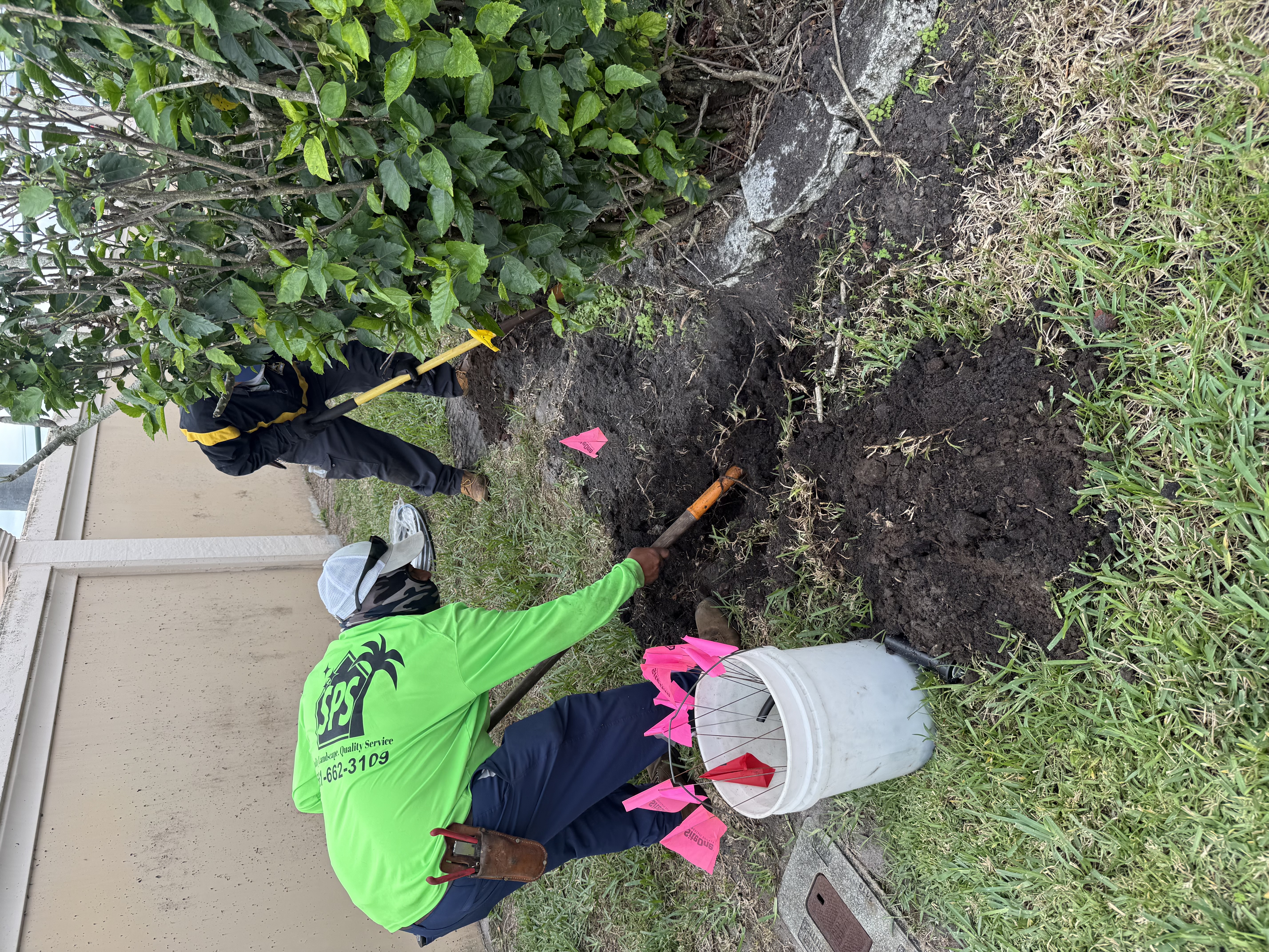 SPS crew in branded green shirts performing irrigation and drainage work at a Florida property
