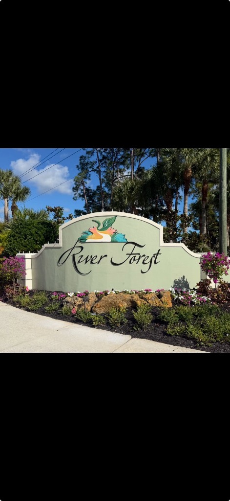 River Forest community sign surrounded by colorful seasonal flowers and tropical plantings